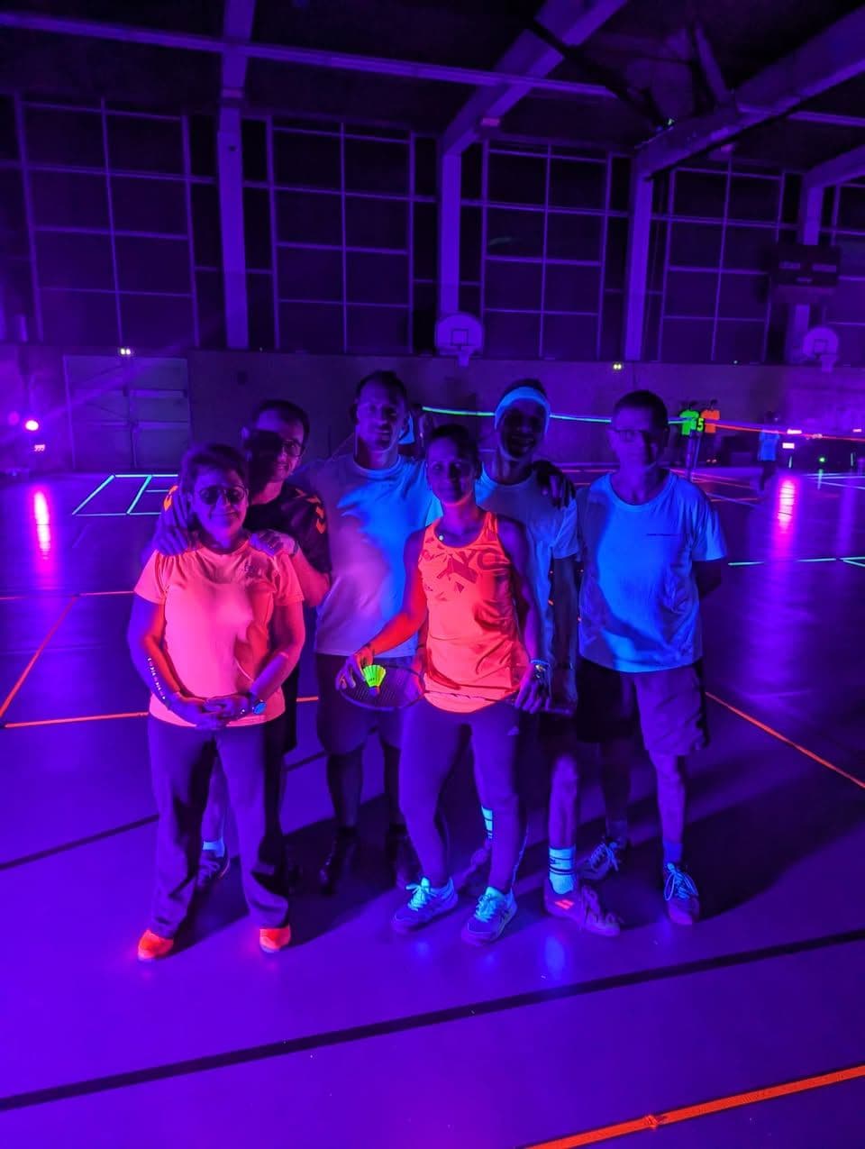 Joueuses et joueurs en tenue fluo lors de la soirée sous lumière noire
